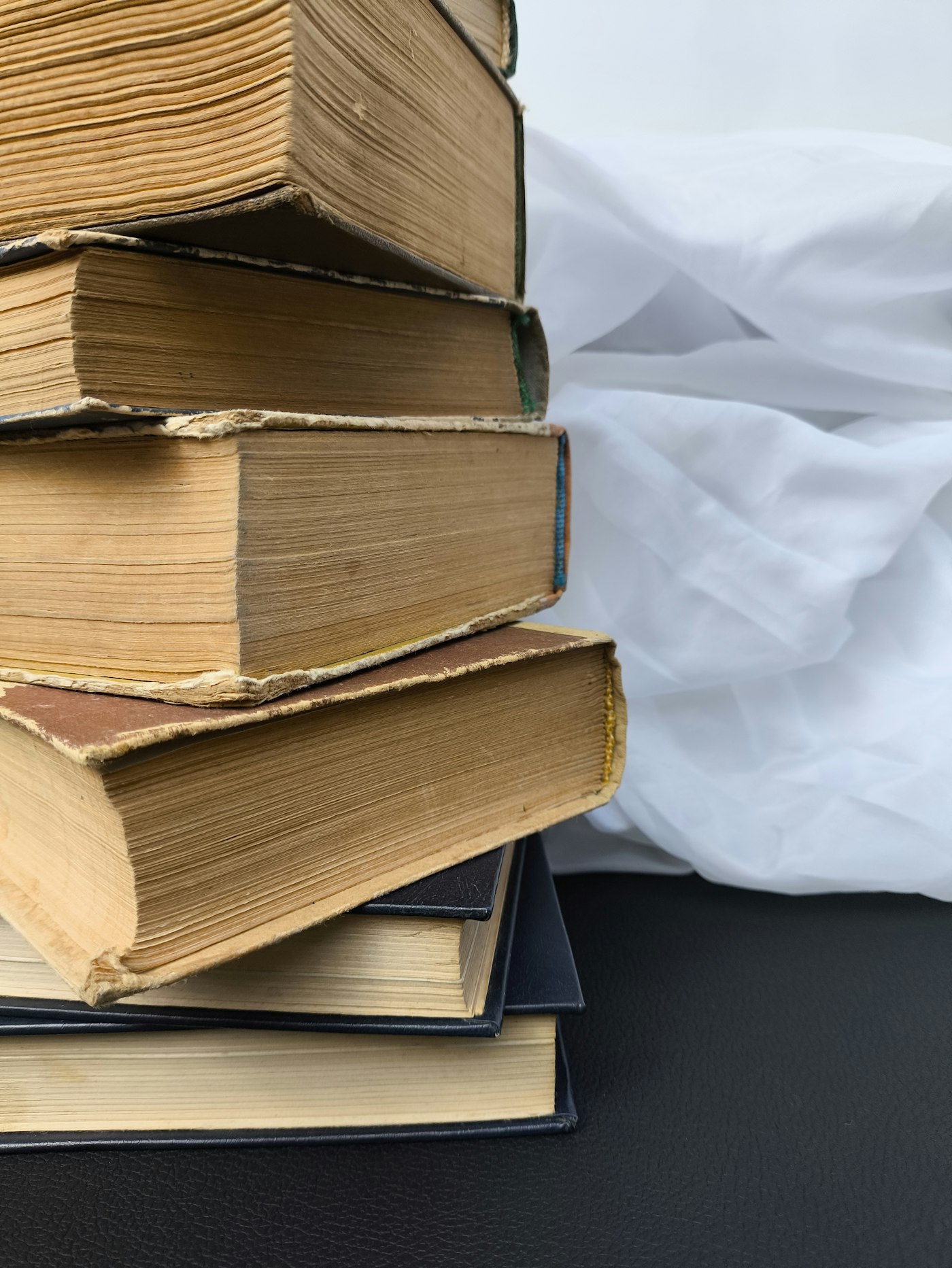 Pila de libros antiguos con los cantos amarillos y las cubiertas desgastadas.